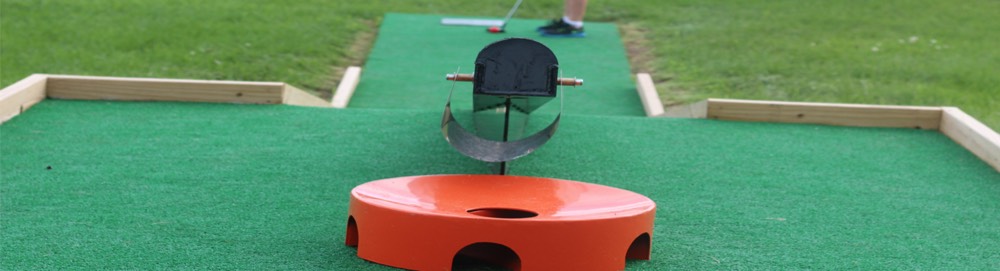 A miniature golf hole at Hillcrest with an orange obstacle on bright turf.